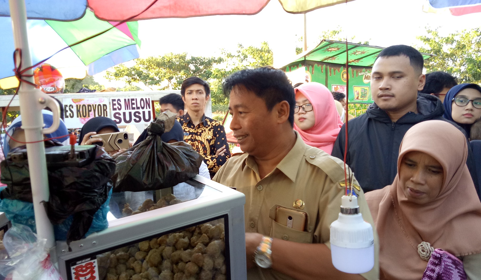 M. Mucklas dari divisi kesehatan lingkungan, kerja dan olahraga dinas kesehatan kota Surabaya saat memberikan penjelasan bahaya plastik hitam untuk makanan pada salah satu pedagang di ITS.  (Foto: Pita/ngopibareng.id)