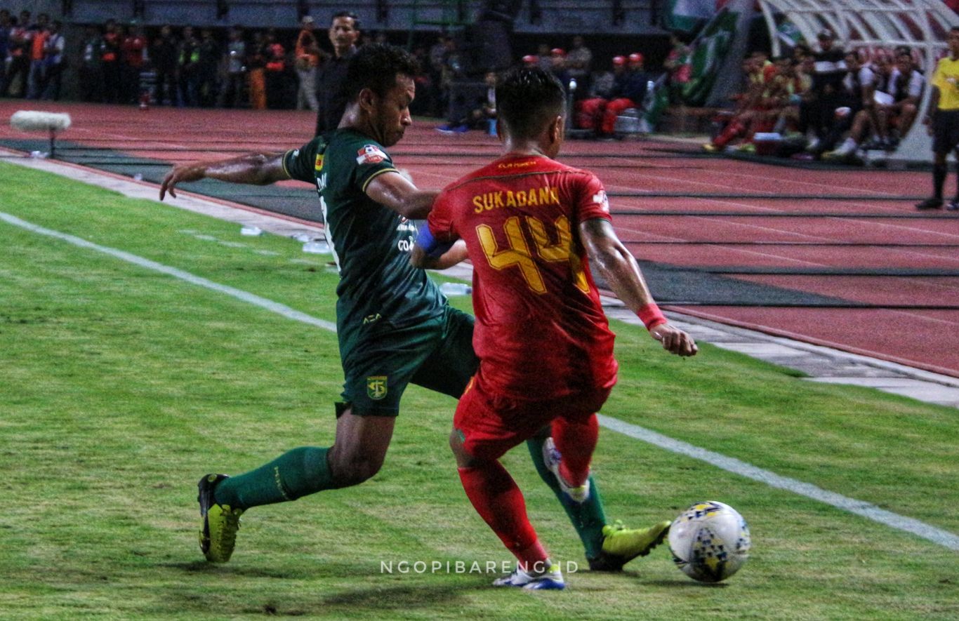Pemain Kalteng Putra I Gede Sukadana saat berebut bola dengan pemain Persebaya Osvaldo Haay. (foto: Haris/ngopibareng.id)