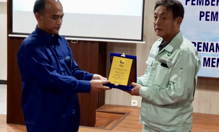 Direktur Komersial dan Bisnis PT Smelting Totsuya Inoeu menerima penghargaan dari Kepala KPP Pratama Gresik Ismail. (Foto Istimewa)