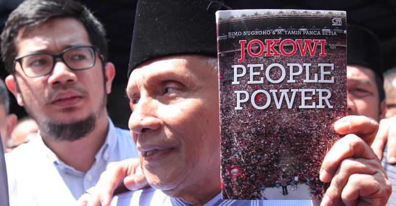 Amien Rais dengan buku Jokowi People Power saat tiba di Polda Metro Jaya. (Foto: detik.com)