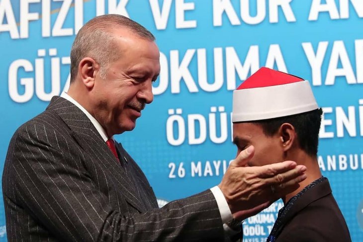 Presiden Turki, Recep Tayyip Erdogan saat memberikan ucapan selamat kepada Qori muda asal Bima, Nusa Tenggara Barat (NTB), Syamsuri Firdaus seusai berhasil meraih juara 1 pada MTQ Internasional ke 7 yang digelar di Istambul, Turki. (Foto Istimewa).