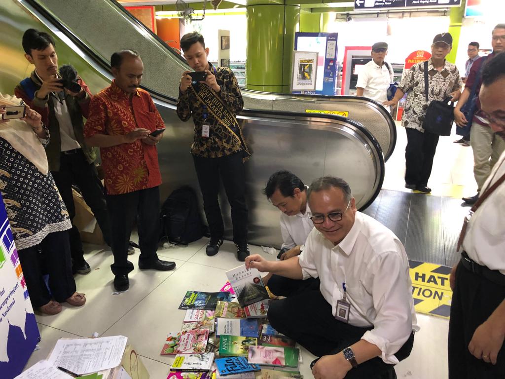 Kepala Badan Pengembangan Bahasa dan Perbukuan, Kemendikbud, Dadang Sunendar, ikut membagikan buku bacaan gratis untuk pemudik di Stasiun Gambir, Senin, 27 Mei 2019.  (Foto: asmanu/ngopibareng.id)