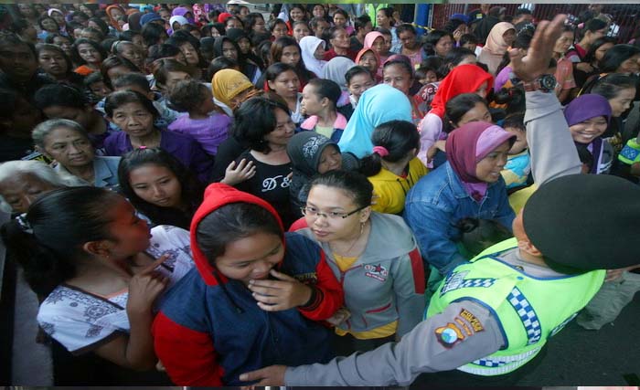 Polisi mengamankan ribuan orang yang antre sedekah PT Gudang Garam di Kediri, Rabu. (Foto:Okezone)