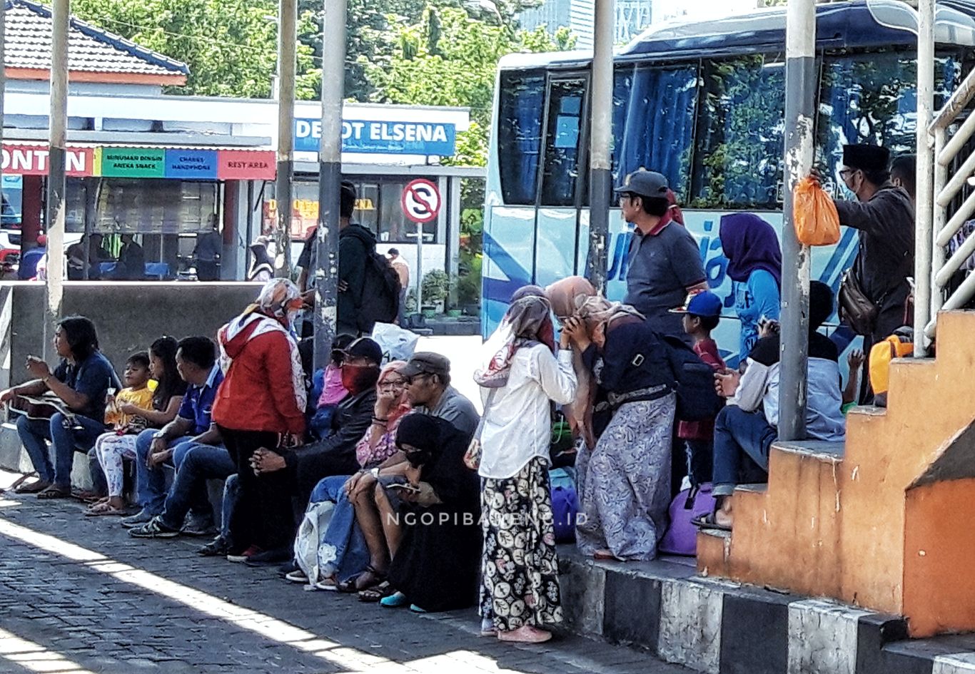 Beberapa orang sedang menunggu kedatangan bus di Terminal Purabaya, Surabaya. (foto: Haris/ngopibareng.id)