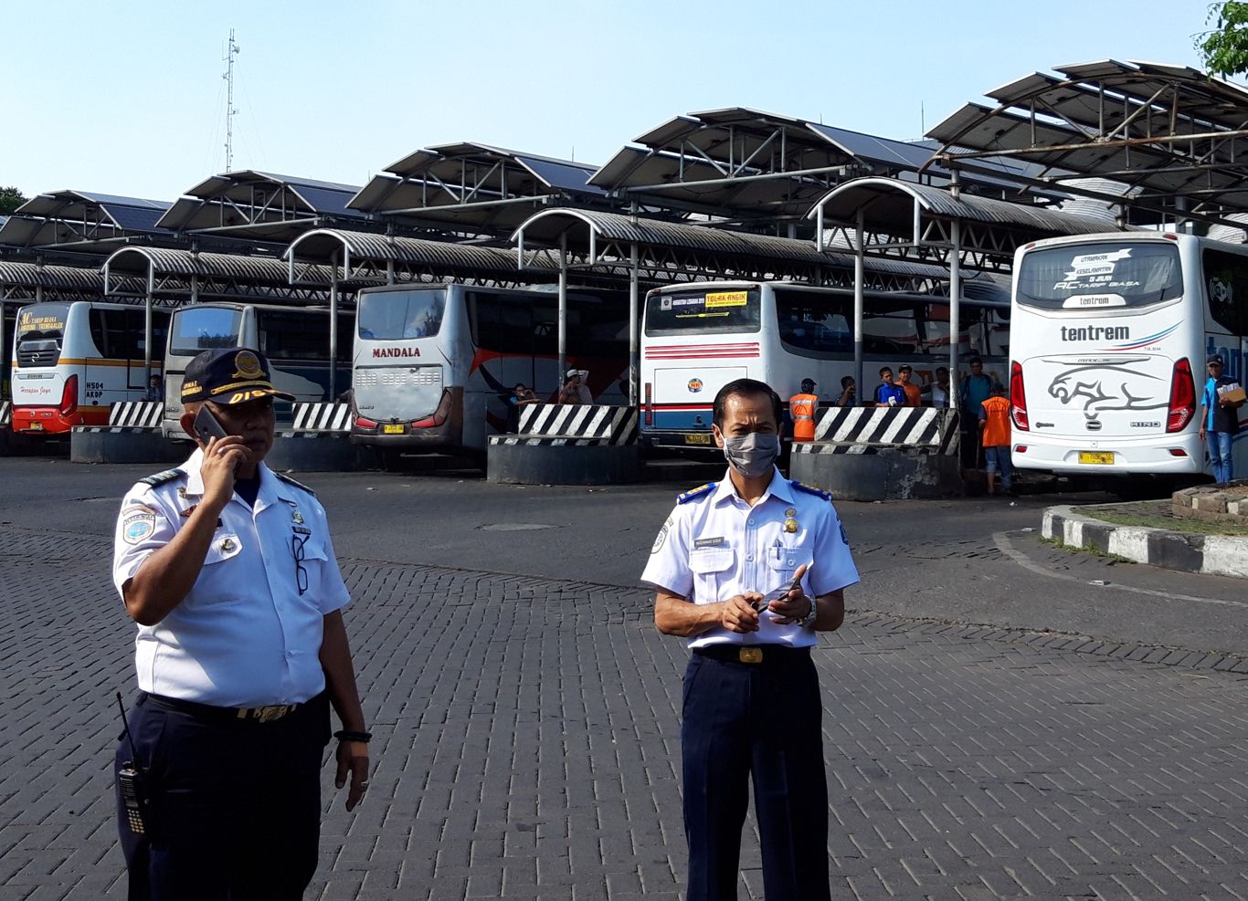Petugas Terminal Purabaya saat mengatur jalur bus agar tidak tejadi antrian panjang. (Foto: Haris/ngopibareng.id)