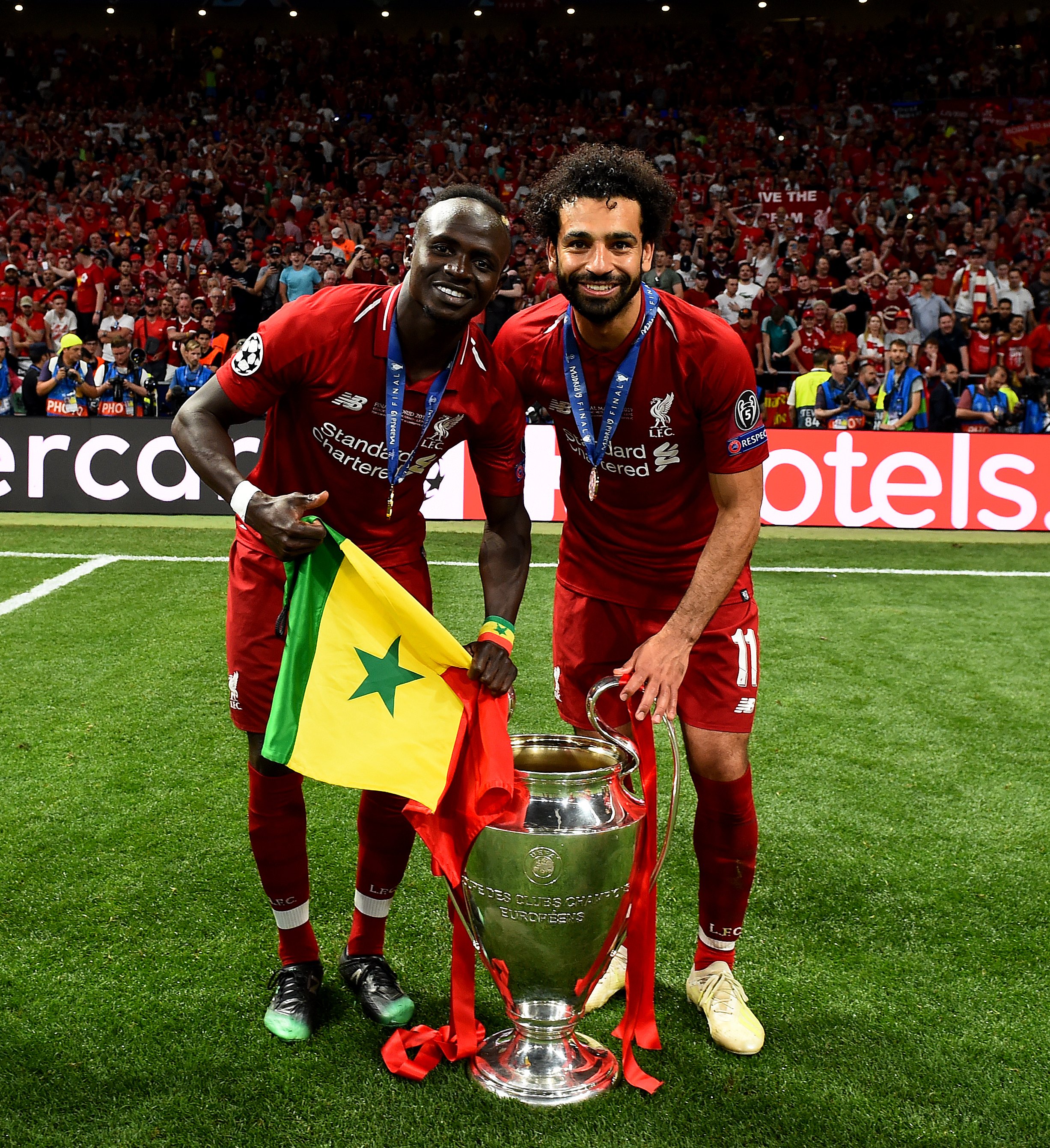 Mo Salah dan Sadio Mane berbagi kebahagiaan dengan berpose bersama trofi Liga Champions. (Foto: Twitter/@LFC)