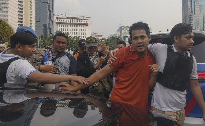 Petugas kepolisian mengamankan seorang pria (kedua kanan) saat berlangsung aksi unjuk rasa kawal sidang sengketa Pilpres 2019, di kawasan Jalan Medan Merdeka Barat, Jakarta, Jumat, 14 Juni 2019. (foto: Antara) 