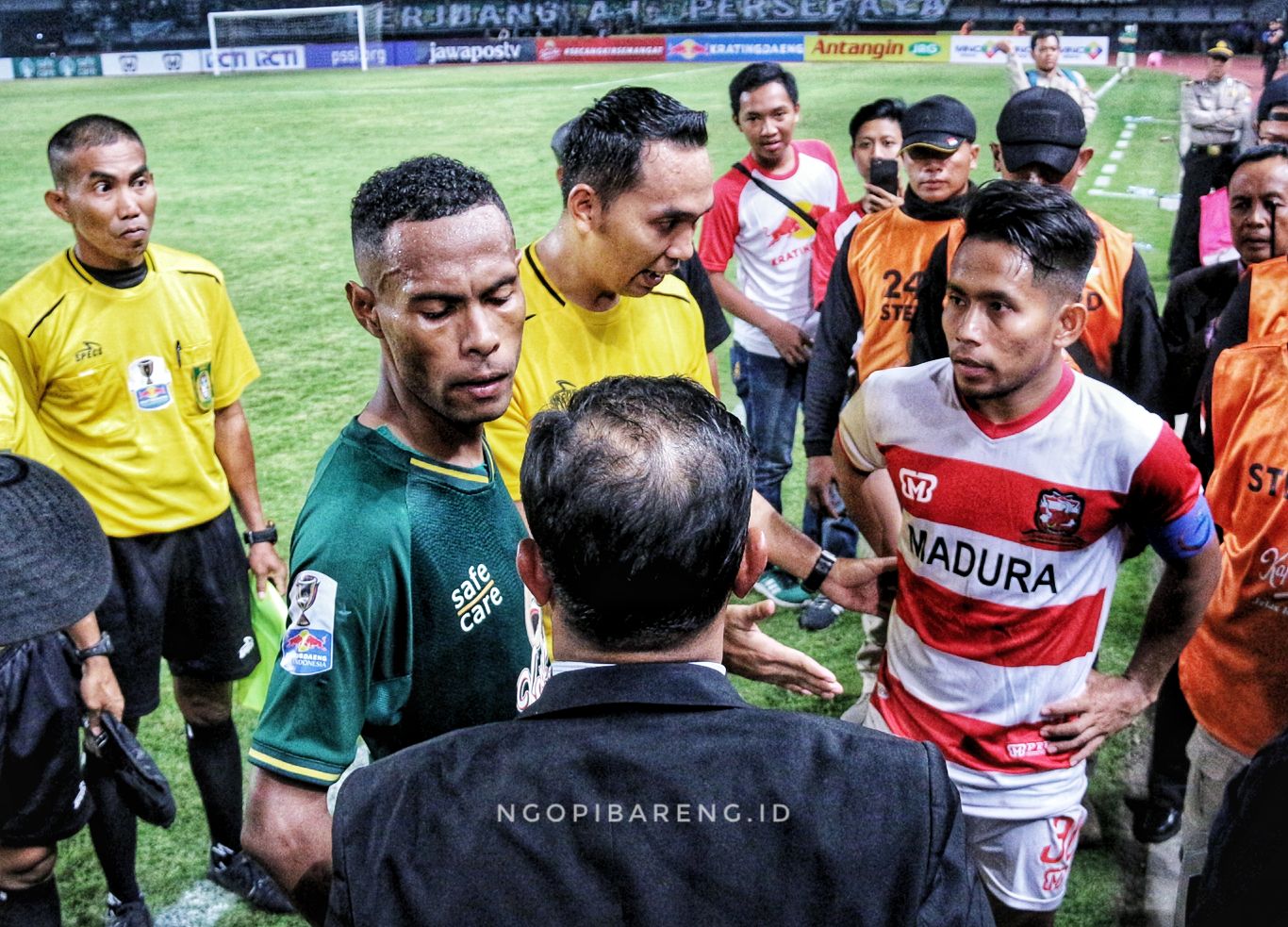 Kapten Persebaya, Ruben Sanadi (hijau) saat melakukan negosiasi soal dihenyikannya pertandingan dengan pemain Madura United, Andik Vermansah. (Foto: Haris/ngopibareng.id)