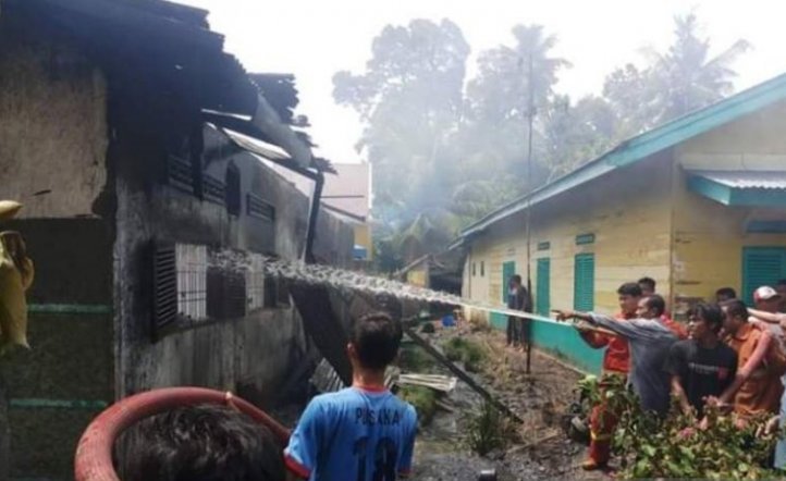 Petugas pemadan kebakaran bersama warga sedang berusaha memadamkan pabrik mancis yang terbakar di Langkat, Sumatera Utara. (Foto: Antara Sumut/Imam Fauzi)