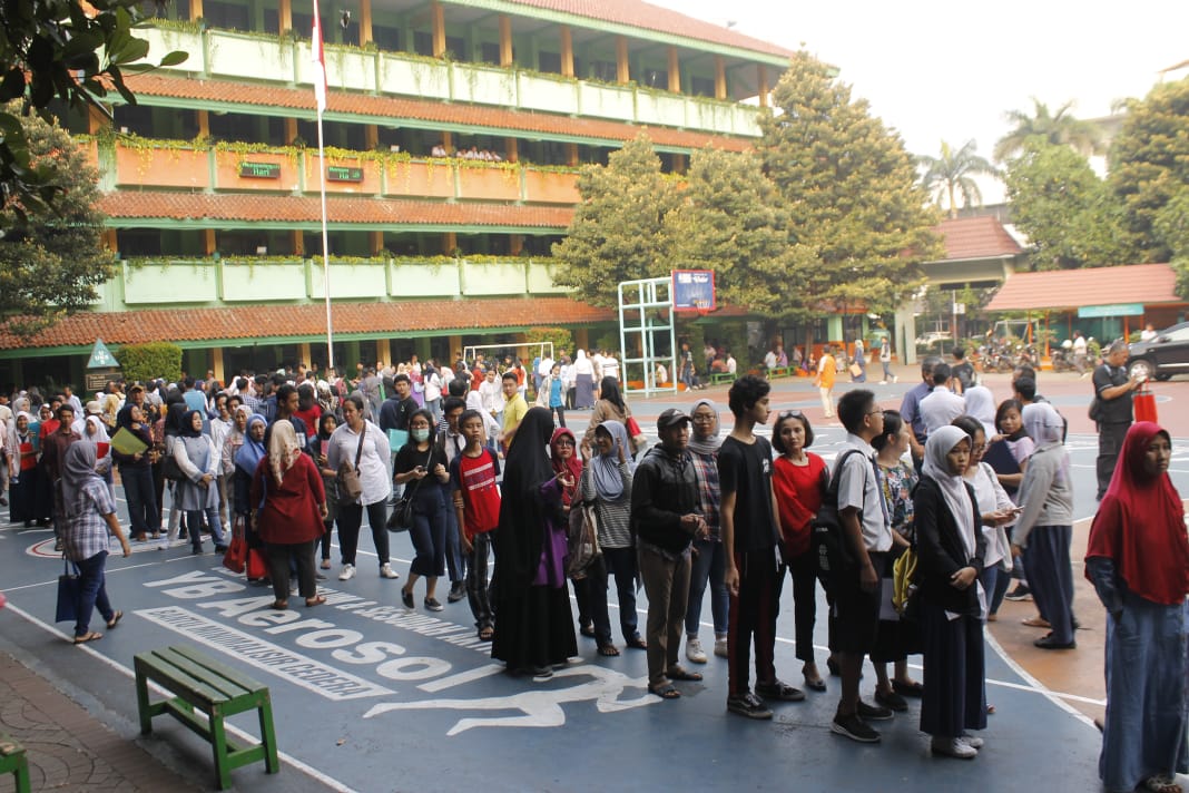 Orang tua rela antre berjam-jam sejak subuh demi anaknya supaya bisa diterima di SMA Negeri 78 Jakarta. (Foto: Asmanu/ngopibareng.id)