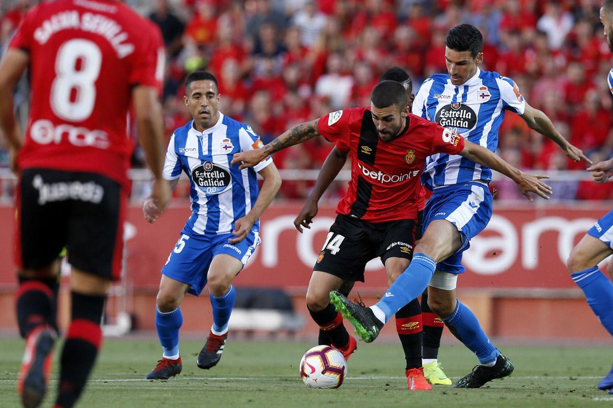 Pemain Mallorca, Salva Sevilla (merah-hitam) berduel lawan pemain Deportivo Lacoruna. (Foto: Twitter/@LaLiga)