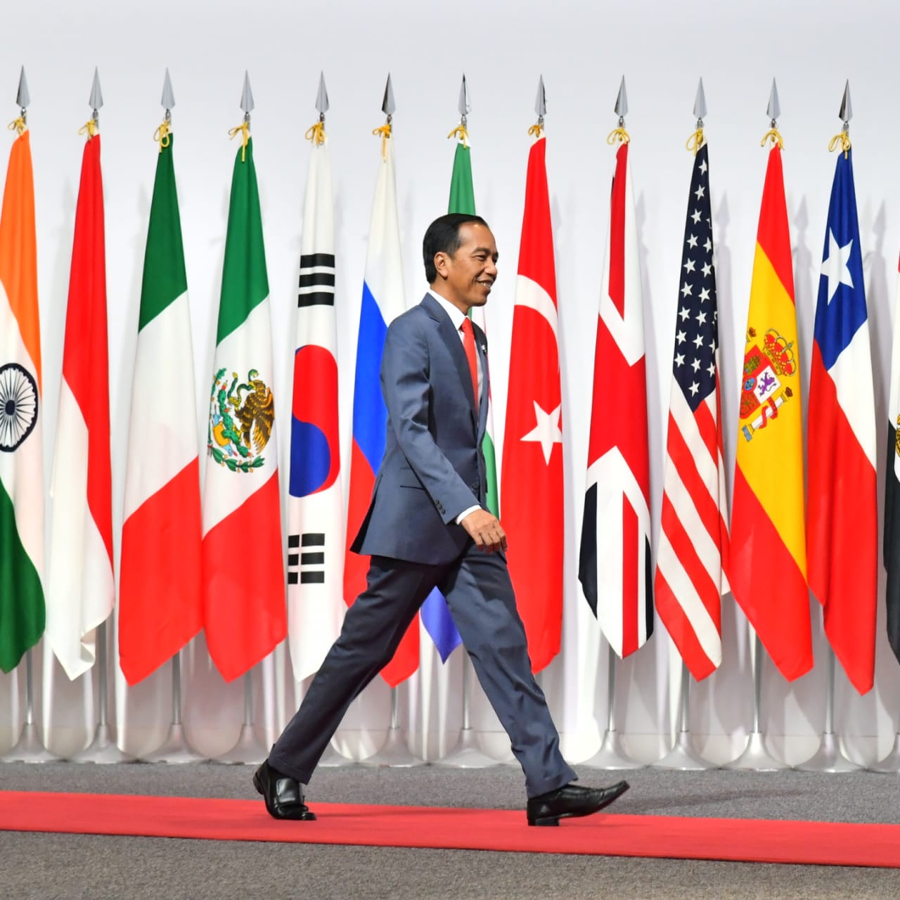 Presiden Joko Widodo berjalan dengan latar belakang bendera-bendera negara anggota G20. (Foto: Setpres)