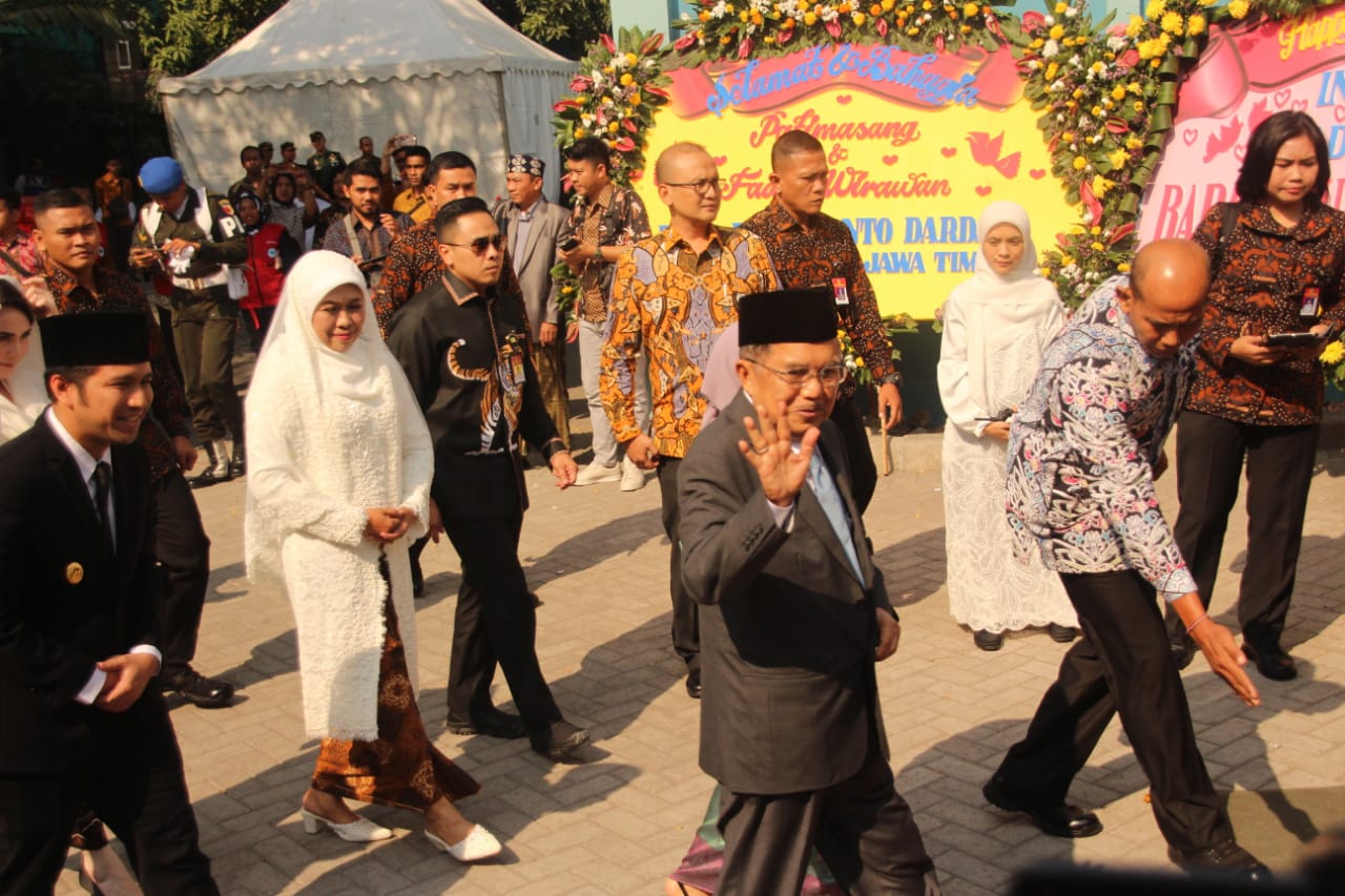 Wakil Presiden Jusuf Kalla melambaikan tangan kepada wartawan dan undangan, saat menghadiri akad nikah anak Khofifah. (Foto: Faiq/ngopibareng.id)