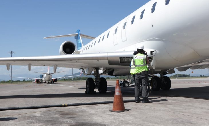Pegawai Pertamina melakukan pengisian bahan bakar avtur pada pesawat di bandara Sultan Hasanuddin, Makasar. (Foto: Antara/Pertamina)