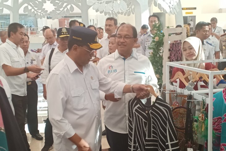 Menteri Perhubungan Budi Karya Sumadi (kiri) sedang memilih kain batik di stan Dekranasda Jawa Barat Bandara BIJB Kertajati, Jawa Barat, Sabtu 6 Juli 2019. ( Foto: Antara/Ahmad Wijaya)
