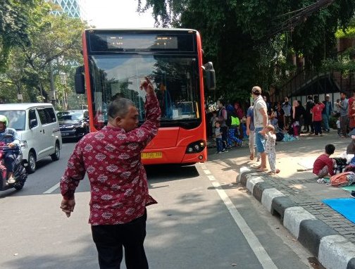  Seorang petugas mengatur parkir bus Transjakarta di jalan Kebon Sirih, Jakarta Pusat, Kamis 11 Juli 2019. Ratusan pencari suaka yang berujuk rasa di depan Kantor UNHCR di Jakarta, ini rencananya akan direlokasi ke tempat penampungan sementara di Jakarta Islamic Center. (Foto: Antara/Sugiharto Purnama)