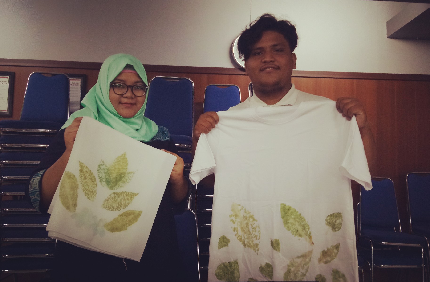 Muhammad Lutfi Aljufri (kanan) memperlihatkan hasil motif kaos dengan warna pigmen daun. (Foto: Pita/ngopibareng.id)