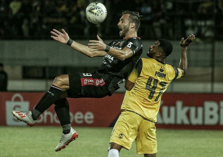 Striker Bali United Illa Spasojevic saat berebut bola dengan bek Barito Putera Donni Monim. (Foto: Instagram @BaliUnited)