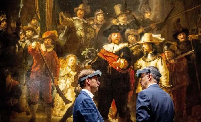 Dua ahli restorasi sedang berdiskusi di depan lukisan karya Rembrandt, The Night Watch atau Penjaga Malam, di Rijksmuseum di Amsterdam. (Foto:CBC)