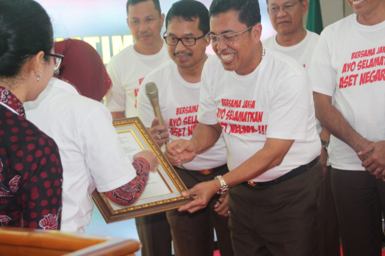 Kepala Kejati Jatim, Sunarta saat menyerahkan aset YKP secara simbolis kepada Wali Kota Surabaya, Tri Rismaharini di Kantor Kejati Jatim, Surabaya. (Foto: Faiq/ngopibareng.id)