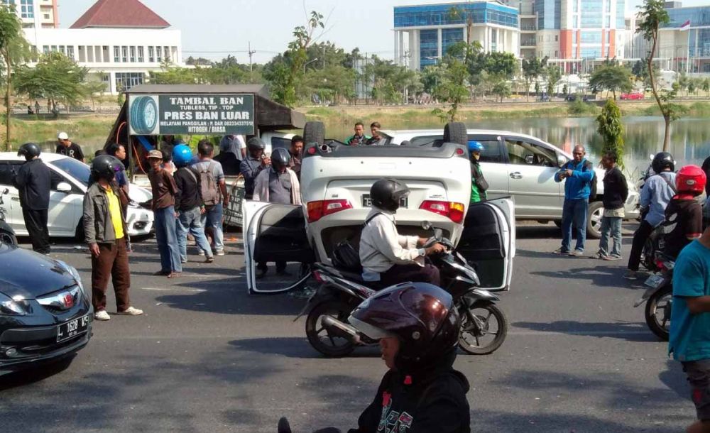 Mobil Mitsubshi Outlander terbalik di Jalan Babatan Unes persisi di depan Danau Universitas Negeri Surabaya (Unesa), Selasa 23 Juli 2019.