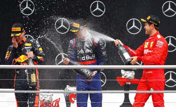 Pebalap Red Bull Max Verstappen (tengah) disiram wine oleh juara dua pebalap Ferrari Sebastian Vettel. Paling kiri  Danill Kvyat daru Toro Rosso juara tiga. (Foto:AFP)
