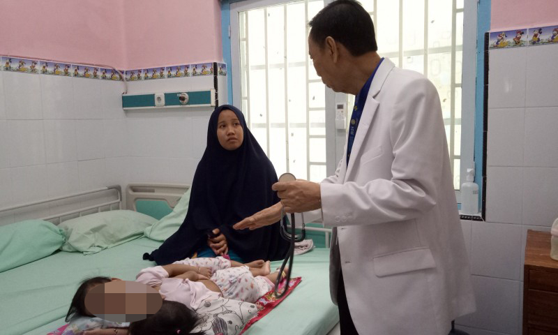 Selviana Dewi saat mendengarkan penjelasan dr. Agus Harianto di kamar rawat inap Instalasi Anak RSUD Dr. Soetomo Surabaya. (Foto: Pita/ngopibareng.id)