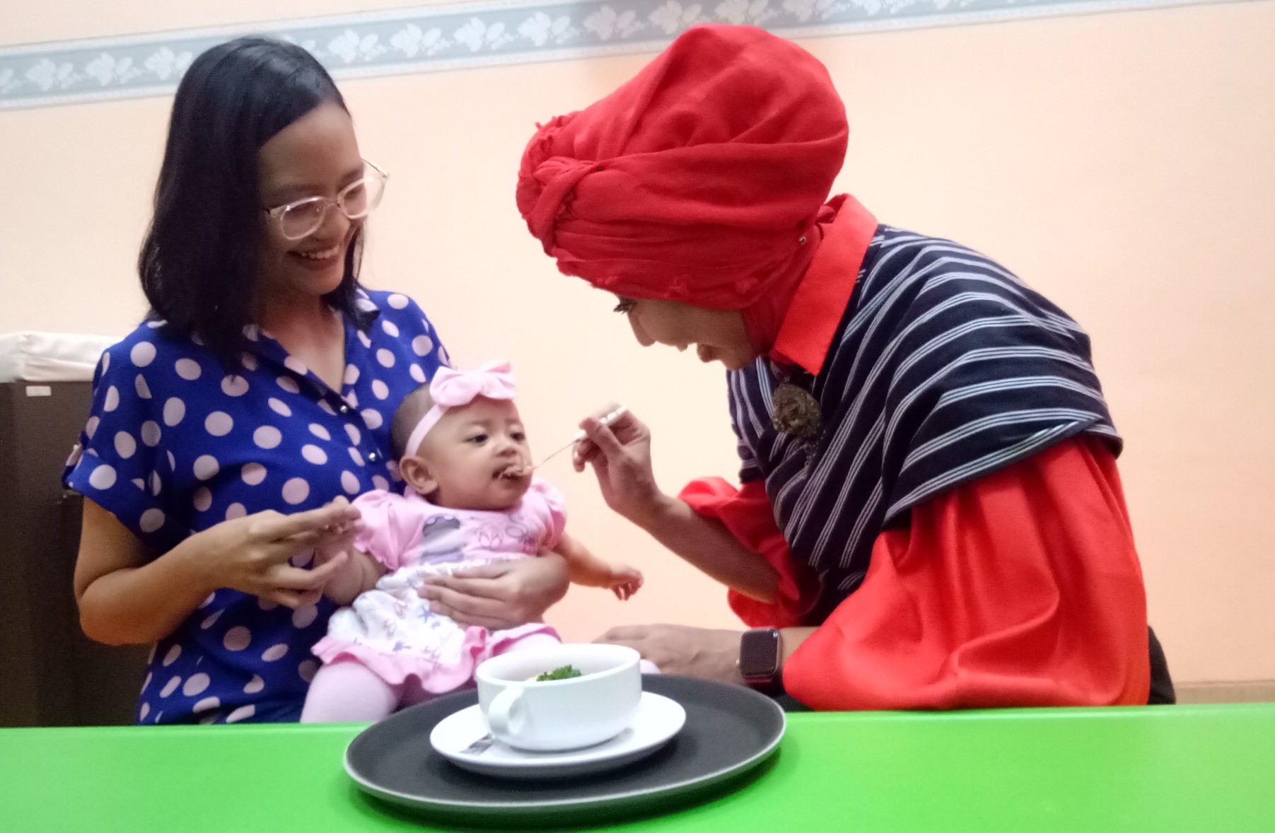 dr. Dini Adityarini,SpA dokter spesialis anak dari Rumah Sakit Ibu dan Anak Kendangsari Merr saat menyuapi menu MPASI dari hati ayam kepada salah satu bayi.  (Foto: Pita/ ngopibareng. Id)  
