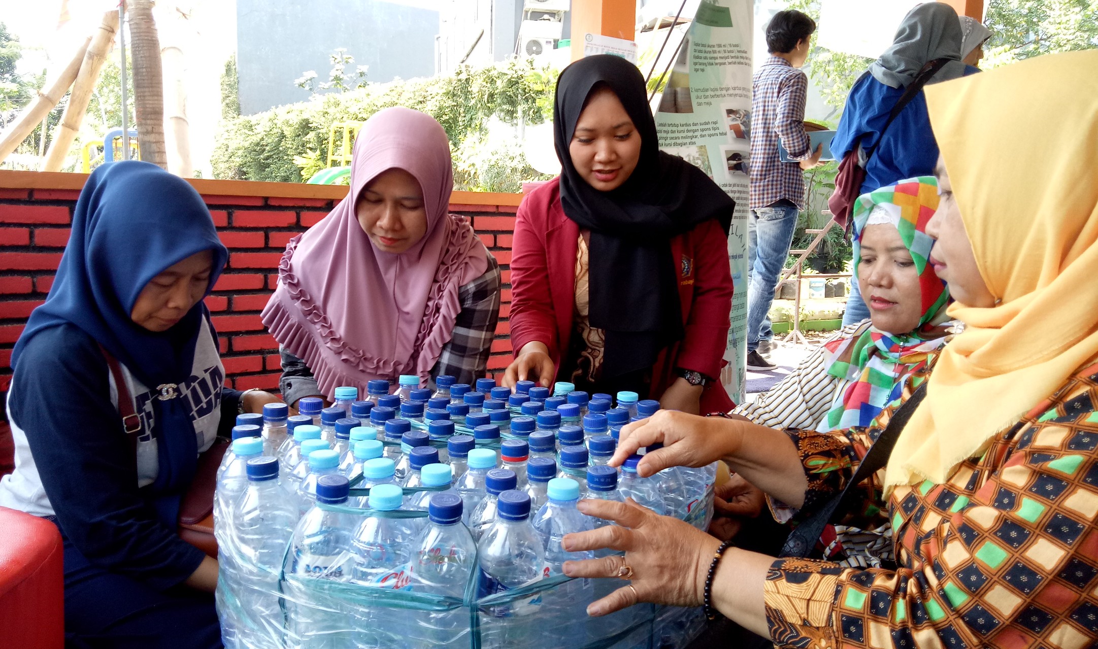 Mahasiswa UMS saat mengajari warga kelurahan Medokan Semampir membuat kursi dari botol plastik bekas (Foto: Pita/ngopibareng.id)