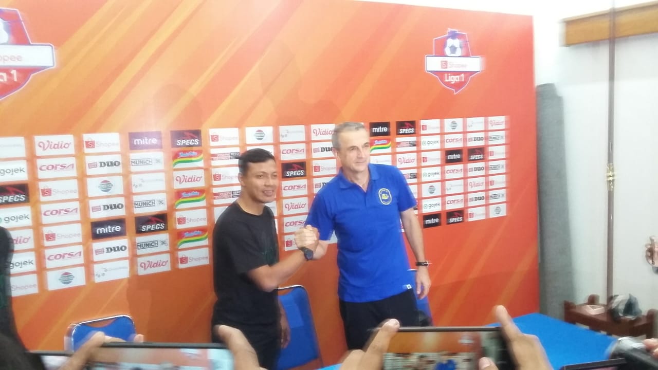 Pelatih caretaker Persebaya, Bejo Sugiantoro berjabat tangan dengan Pelatih Arema Fc, Milomir Seslija ketika sesi konferensi pers (Theo/ngopibareng.id)