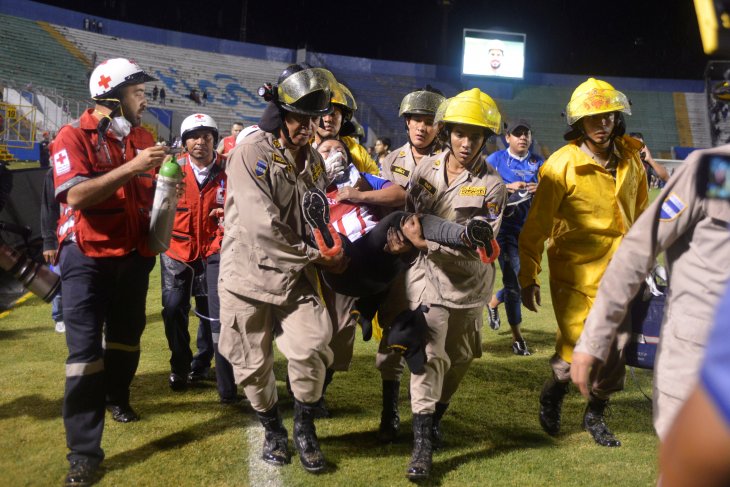 Tim pemadam kebakaran mengevakuasi seorang wanita setelah tiga orang tewas dalam kerusuhan sebelum sebuah pertandingan sepak bola berlangsung antara dua tim bermusuhan di Stadion Nasional Tegucigalpa, Honduras, Sabtu, 17 Agustus 2019.  (Foto: Reuters)