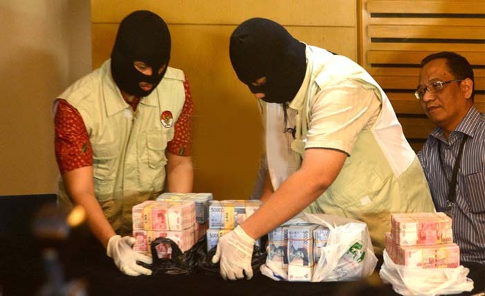 Penyidik KPK menunjukkan tumpukan uang yang diamankan dari kasus suap di Dinas PU Yogyakarta. (Foto:Republika)