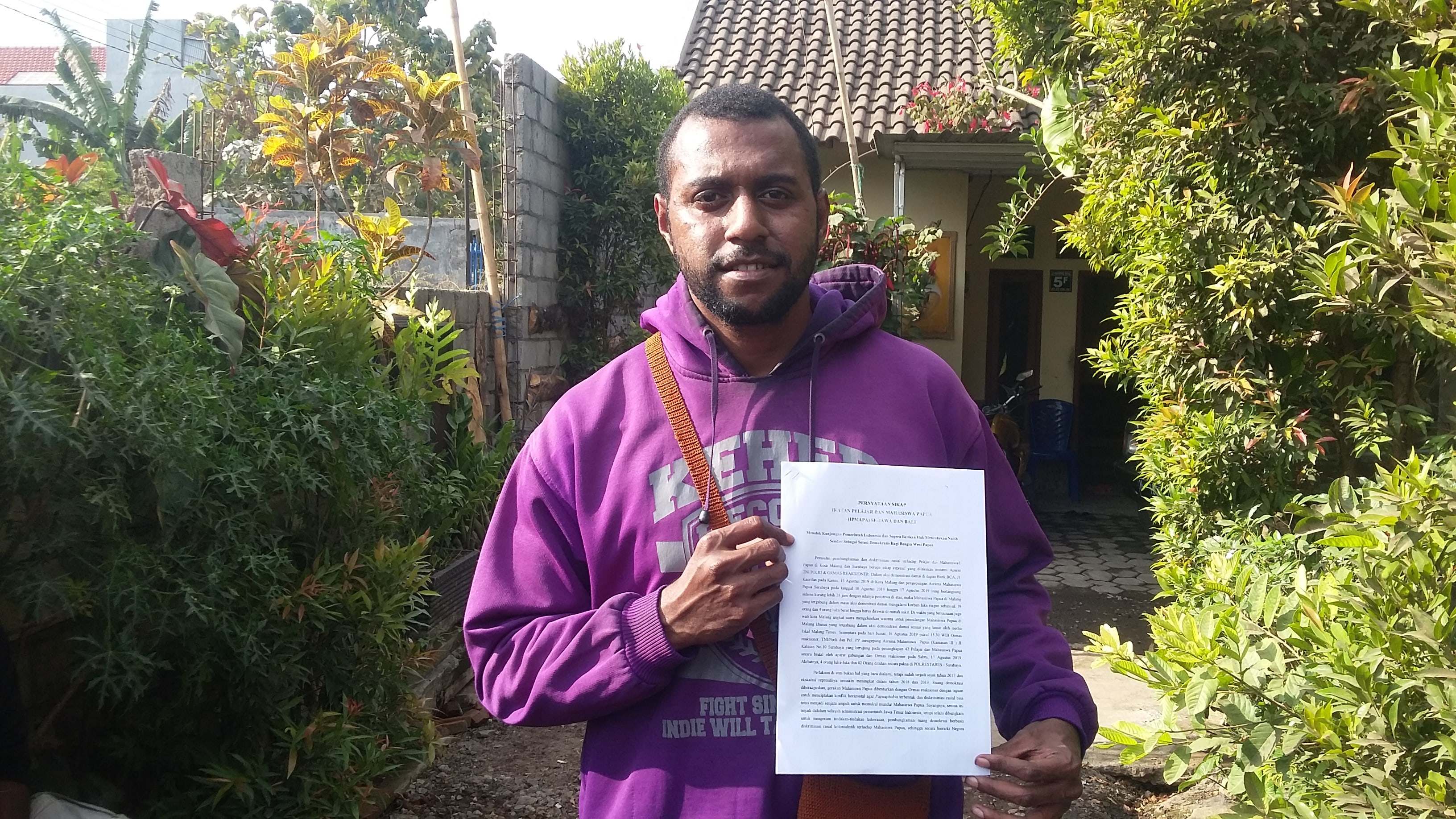 David Christian, mahasiswa asal Timika Papua, memperlihatkan rilis pernyataan sikap IPMAPA se-Jawa dan Bali, pada Minggu 25 Agustus 2019. (Foto: Theo/ngopibareng.id)