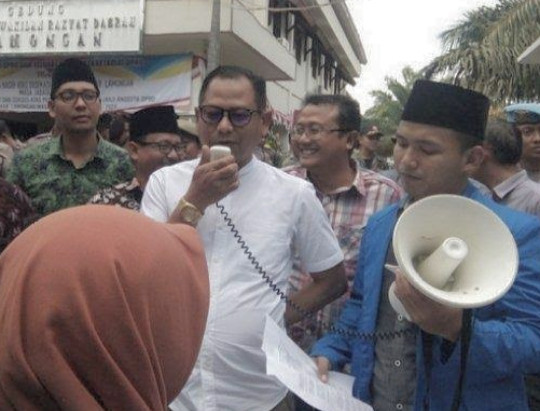 Ketua DPRD Lamongan, Abdul Ghofur (baju putih), menemui massa aksi demonstrasi PMII. (Foto: Nasih/ngopibareng.id)