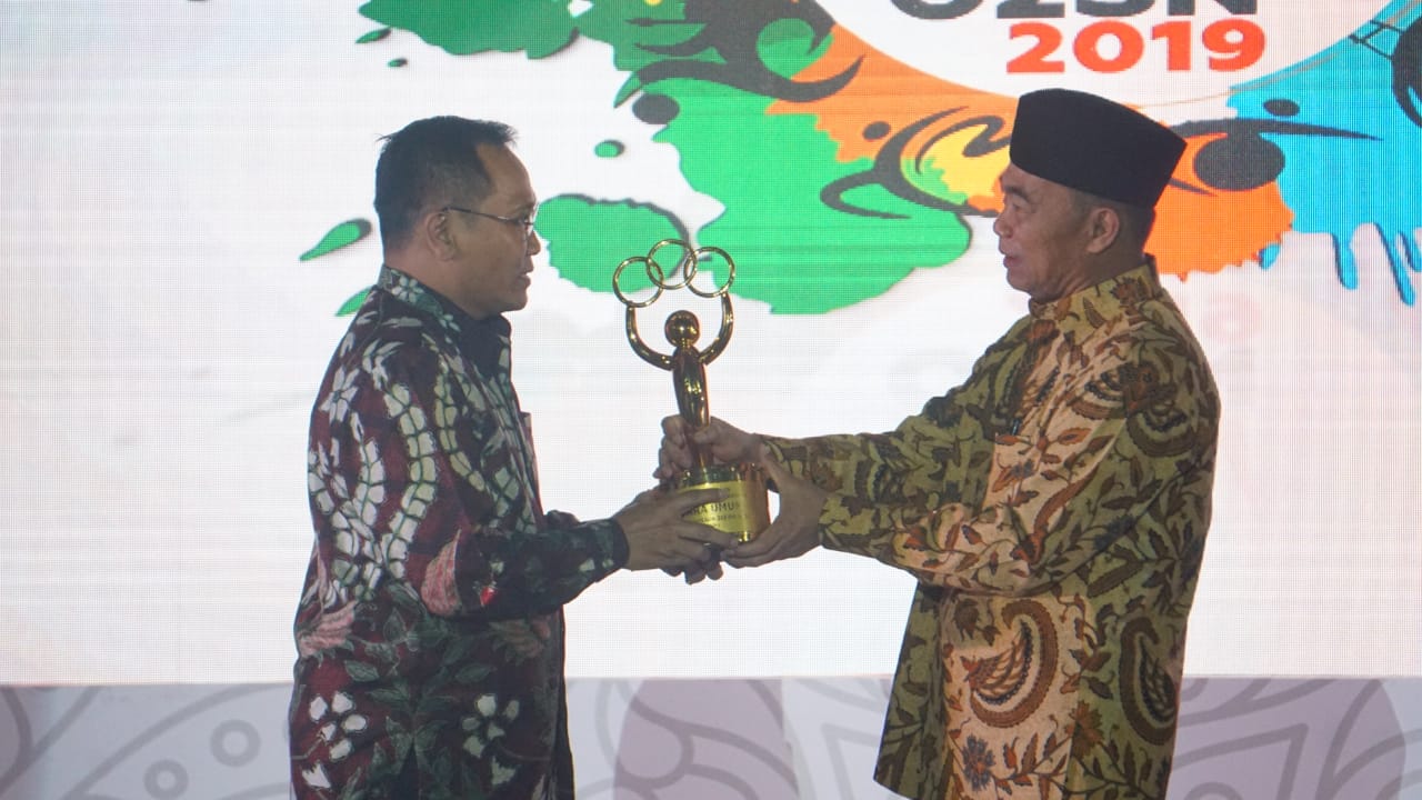 Mendikbud Muhadjir Effendy menyerahkan penghargaan kepada perwakilan Jawa Timut sebagai juara umum O2SN 2019. (Foto: BKLM Kemendikbud)