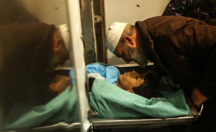 Jenazah remaja Palestina yang ditembak tentara Israel, dicium ayahnya, di Gaza. (Foto:Wafa)