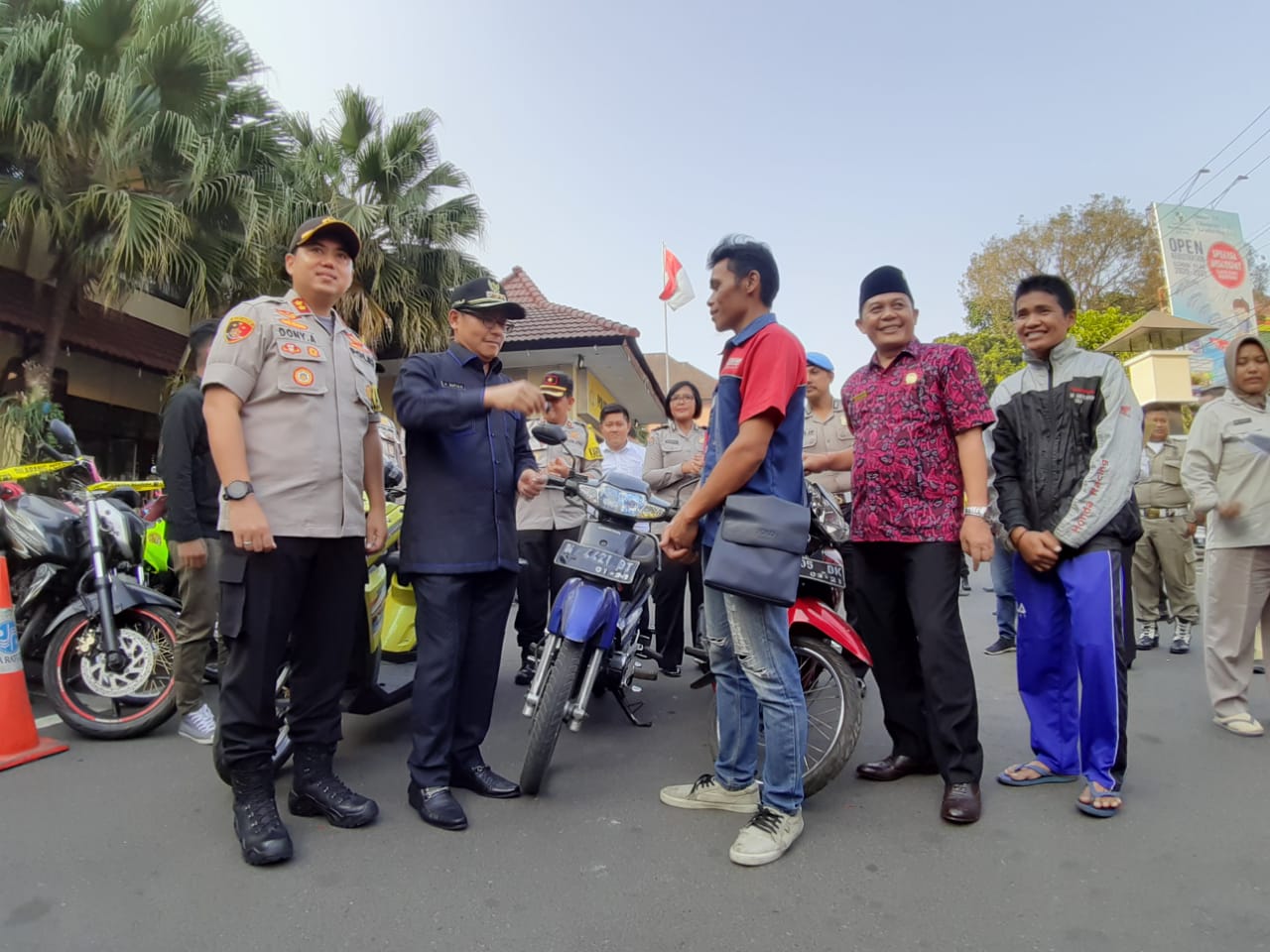 Wali Kota Malang, Sutiaji ketika mengembalikan kunci motor hasil sitaan kepada pemiliknya di halaman Mapolresta Malang. (Foto: Theo/ngopibareng.id)