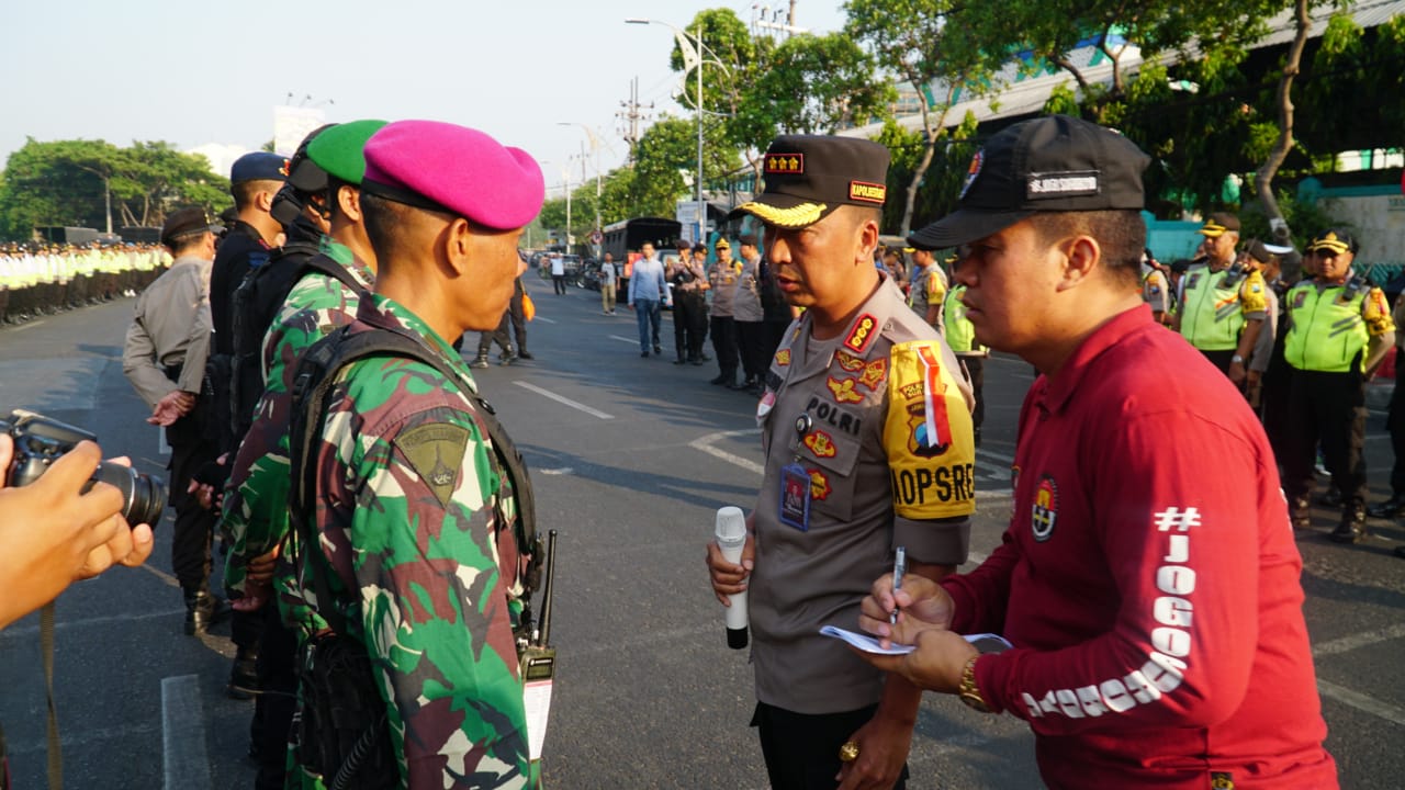 Kapolrestabes Surabaya Kombes Pol Sandi Nugroho saat berkoordinasi dengan aparat yang menjaga demonstrasi di depan DPRD Jatim. (Foto: Faiq/ngopibareng.id)
