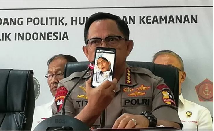 Kapolri Jenderal Pol. Tito Karnavian menunjukkan foto salah satu anggotanya yang masih koma akibat bentrokan massa di Wonogiri, Jawa Tengah, saat konferensi pers di Jakarta, Kamis 26 September 2019. (Foto: Antara/Zuhdiar Laeis)
