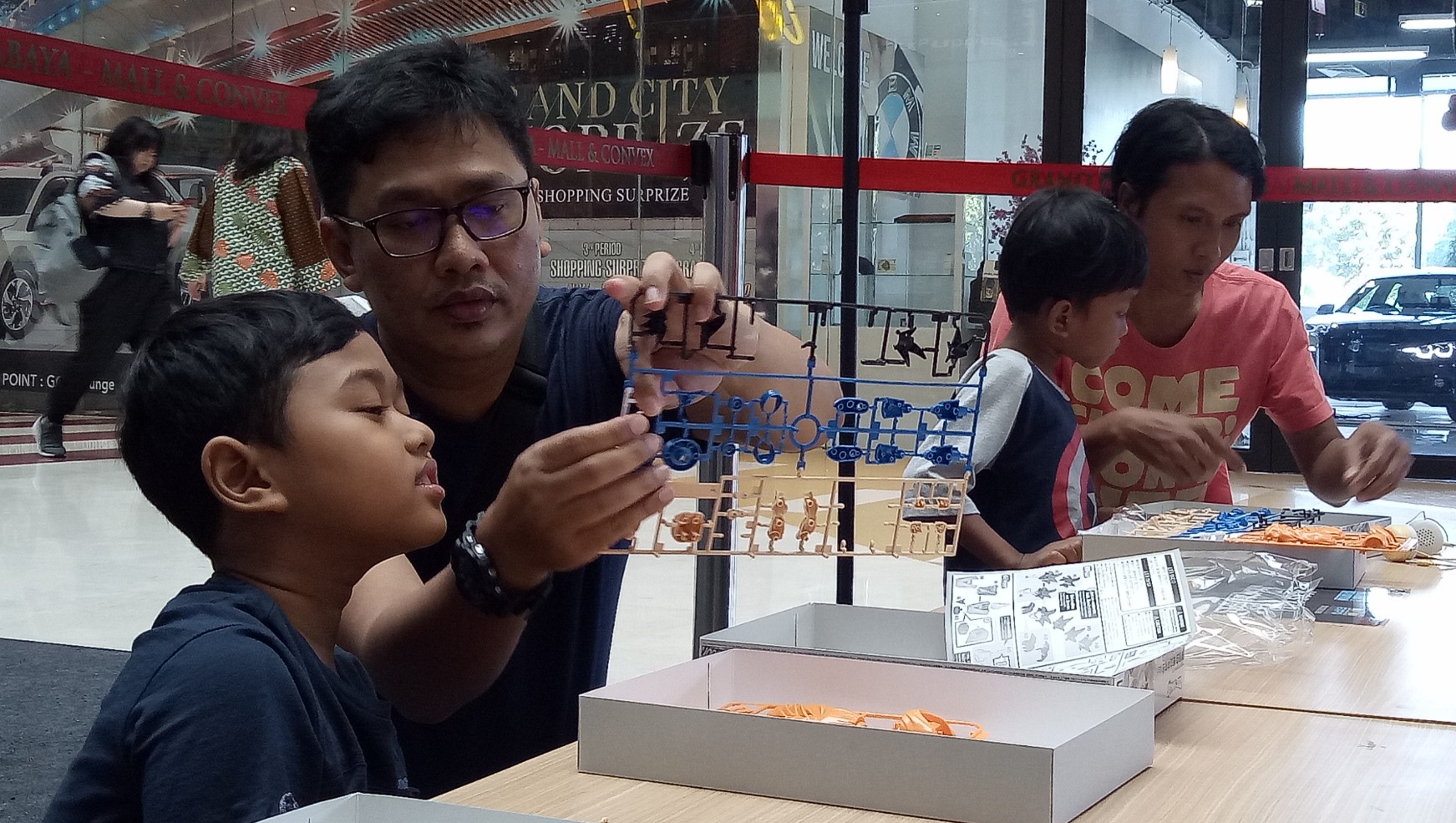 Permainan bongkar pasang seperti lego atau gundan, yang dimainankan oleh ayah dan anaknya di area Mall Grand City Surabaya.  (Foto: Pita/ngopibareng.id)