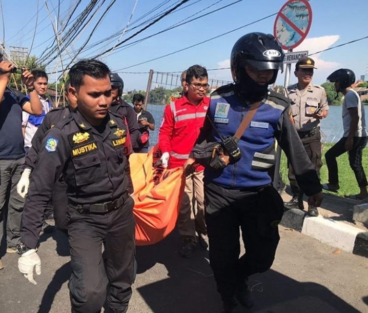 Proses evakuasi jenazah wanita yang diduga bunuh diri di Jembatan Kali Rolak Gunung Sari Surabaya. (Foto: CC112 Surabaya)