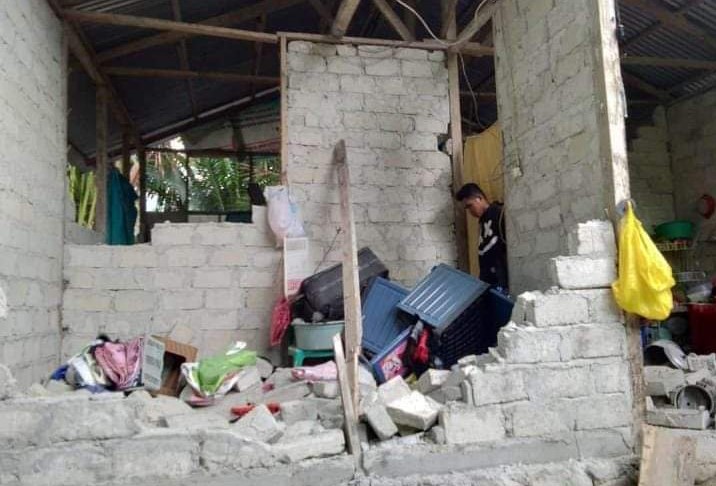 Seorang warga sedang mengevakuasi barang-barang perabot yang tertimbun reruntuhan rumahnya. (Foto: Twitter)