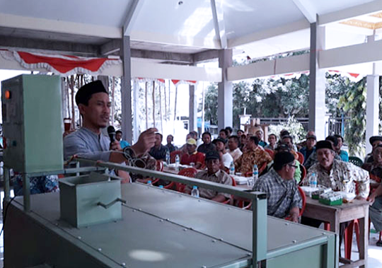 Zainal Abidin, Ketua tim Diseminasi Hasil Teknologi Bagi Masyarakat, saat menerangkan cara kerja alat pengering portable, ke kelompok tani desa di Lamongan. (Foto: Nasih/ngopibareng.id)