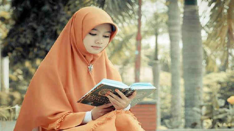 Seorang Muslimah tengah membaca Al-Quran. (Foto: dok/ngopibareng.id)