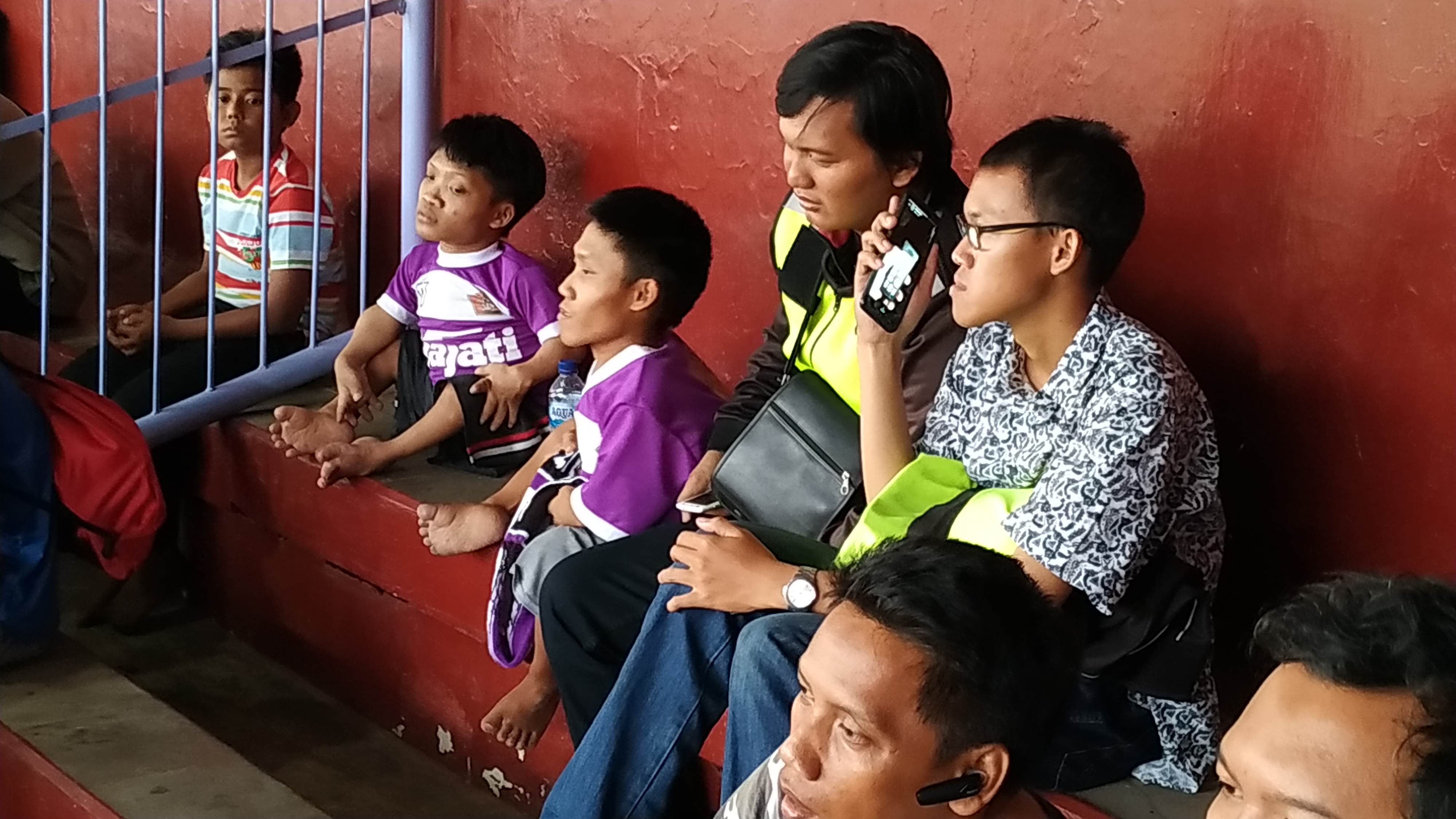 Hendra penderita disabilitas bersama adiknya nonton pertandingan sepak bola di stadion Brawijaya Kediri (Foto: Fendi/ngopibareng.id)