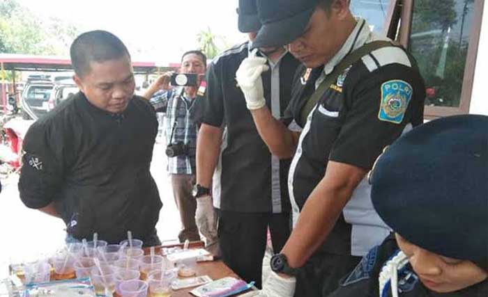 Anggota DPRD kabupaten Kapuas, Berinto (kiri), saat dites urine oleh Polda Kalteng. (Foto:Antara)