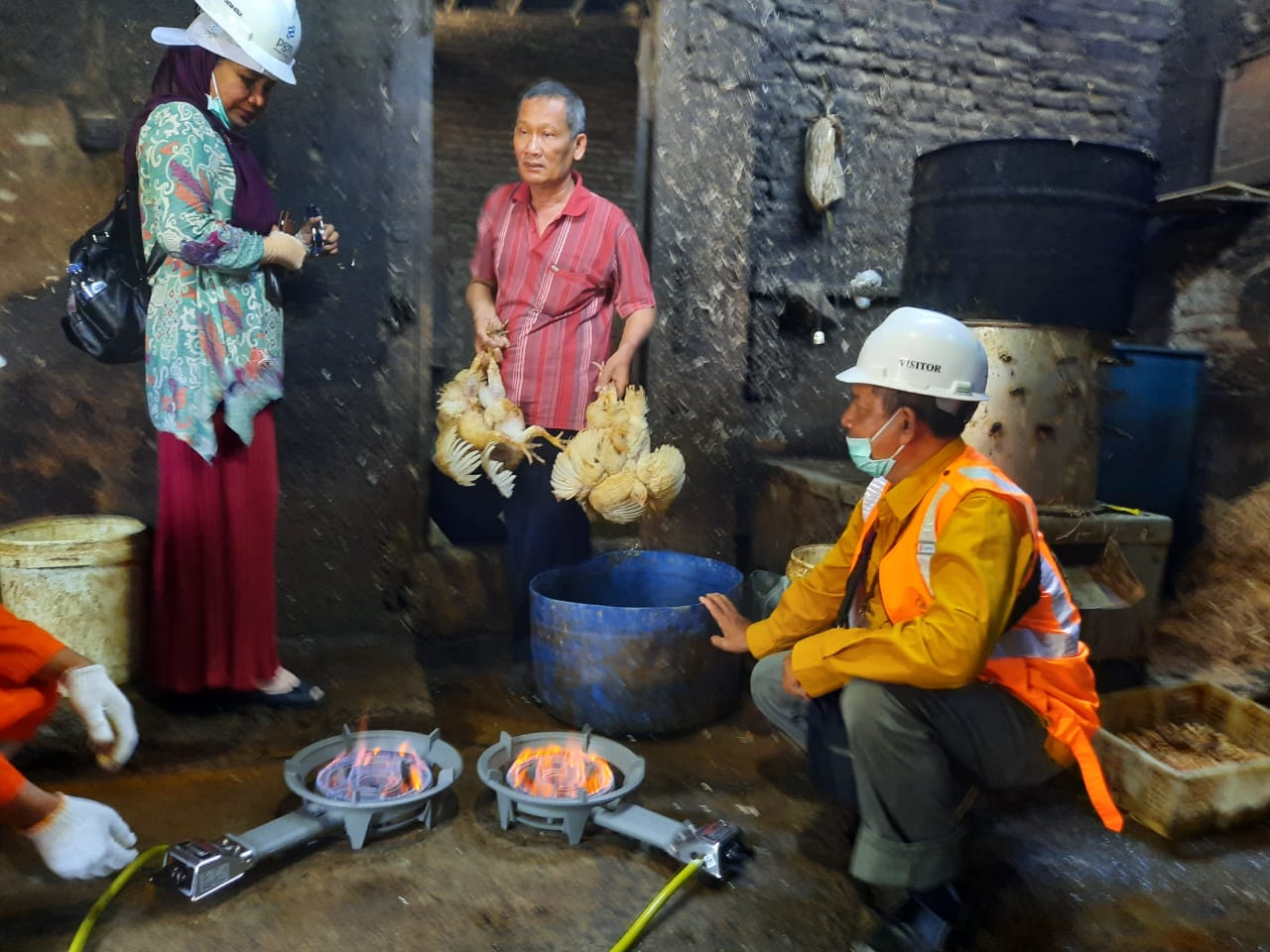Takwin (memegang ayam), bersama tim dari PGN saat pemasangan jargas di tempat usahanya. (Foto: Alief/ngopibareng.id)