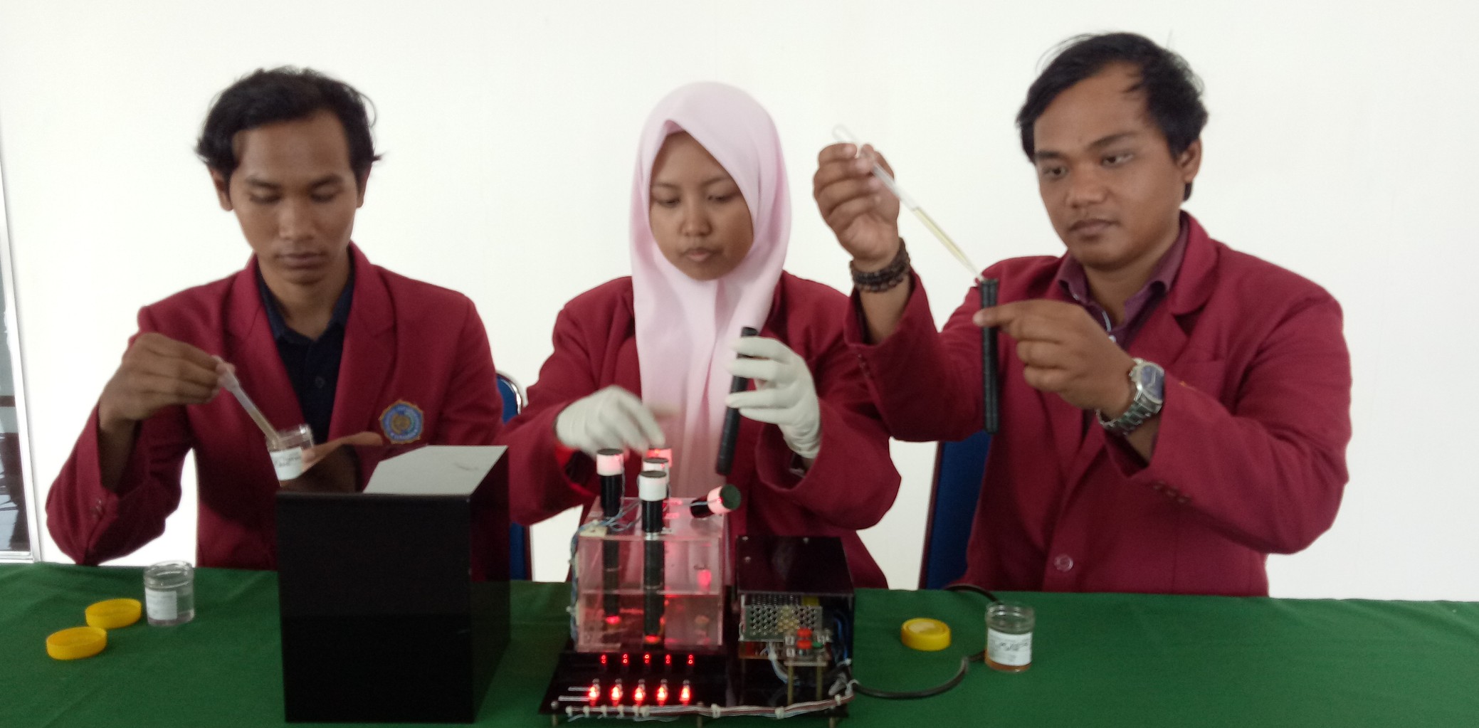 Selvia Nurul Damayanti, Khusnud Dhonni, dan Ghois Qurniawan saat menunjukan cara kerja alat inovasi mereka yaitu Tespi OM (Foto: Pita/ngopibareng.id)
