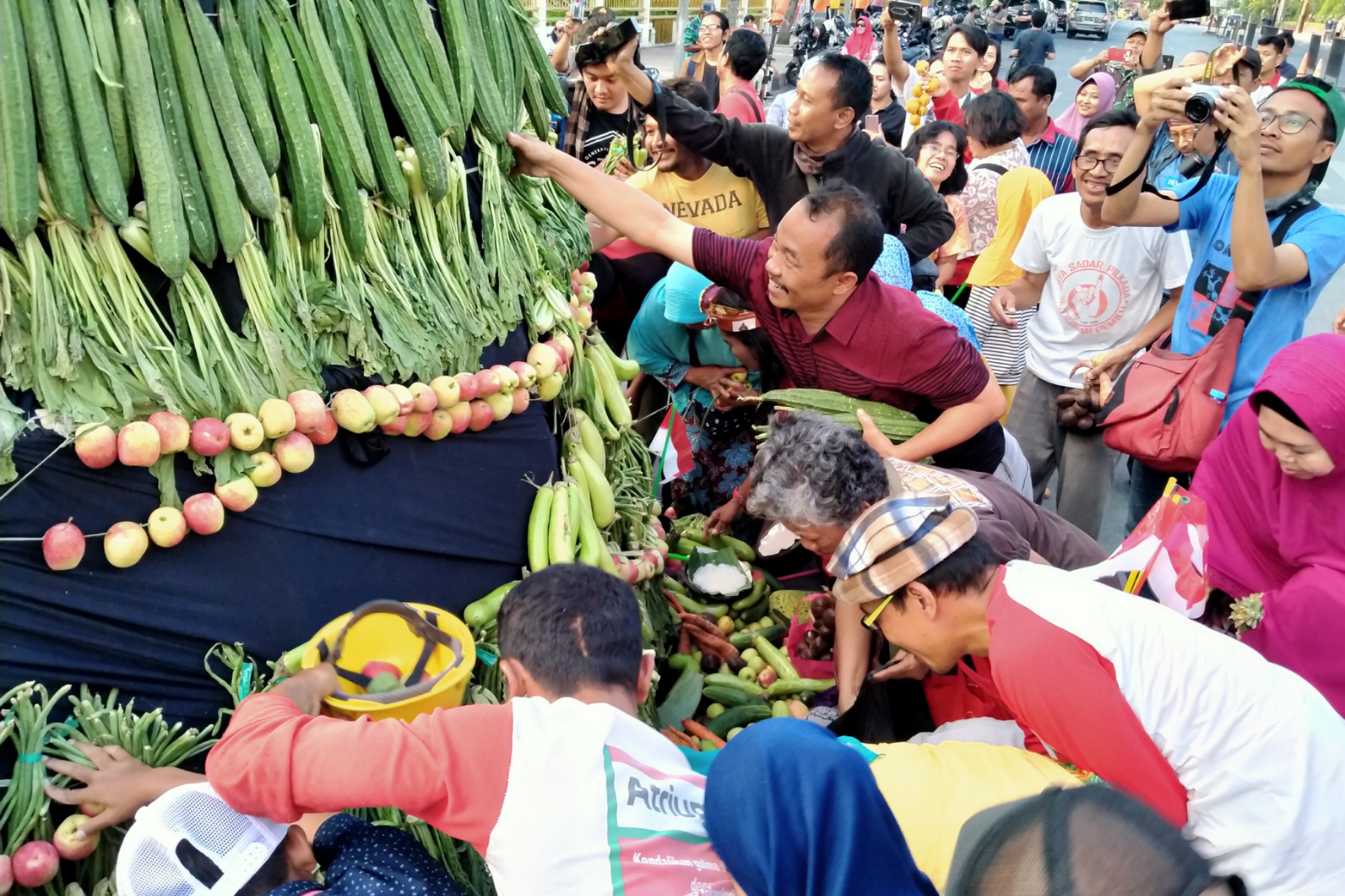 Warga berebut tumpeng sayuran dalam kegiatan tasyarakuran Grebeg Surobouo Jogo Nusontoro di depan Gedung DPRD Surabaya, Minggu 20 Oktober 2019. (Fariz/ngopibareng.id) 