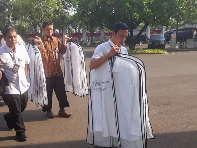 Staf Kepresidenan sibuk membawa kemeja putih baru yang masih terbungkus rapi.